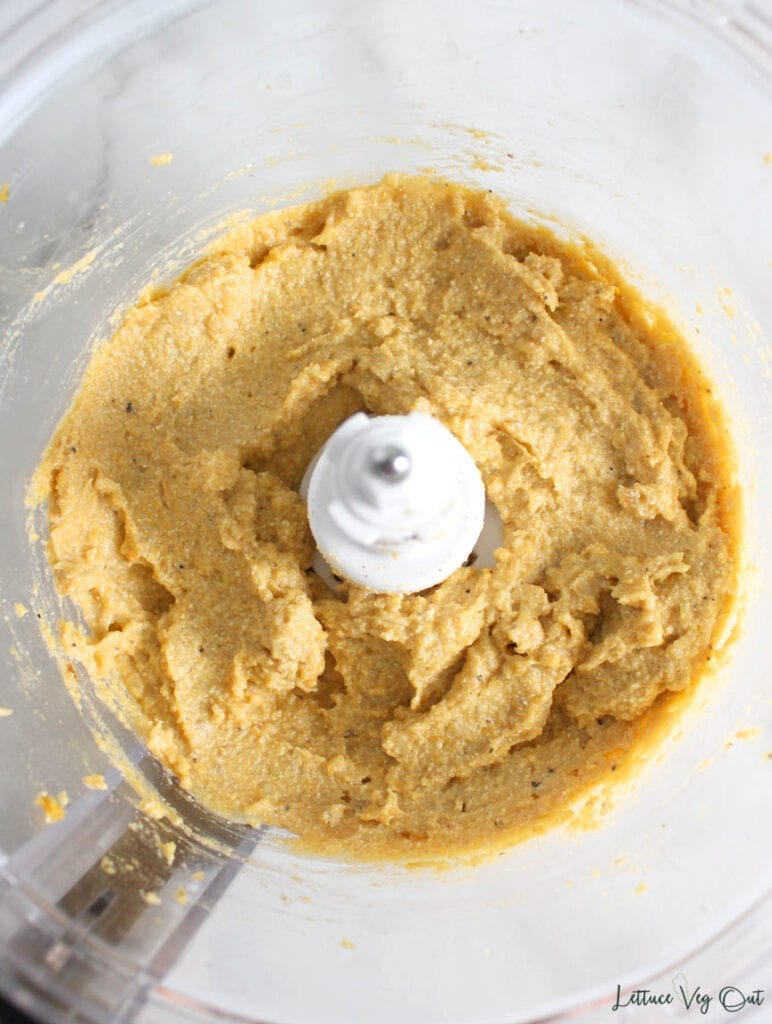 Food processor filled with blended butternut squash ravioli filling (light orange color)