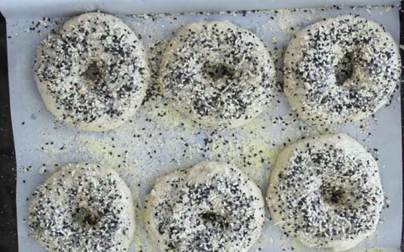 Image of fully formed everything bagels with the poppy seed, sesame seed, onion and garlic toppings layered on.