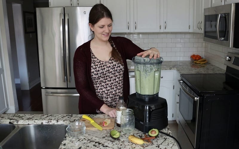 A Vitamix blender combining all the whole, plant-based ingredients together to create a smooth, green apple cinnamon protein shake