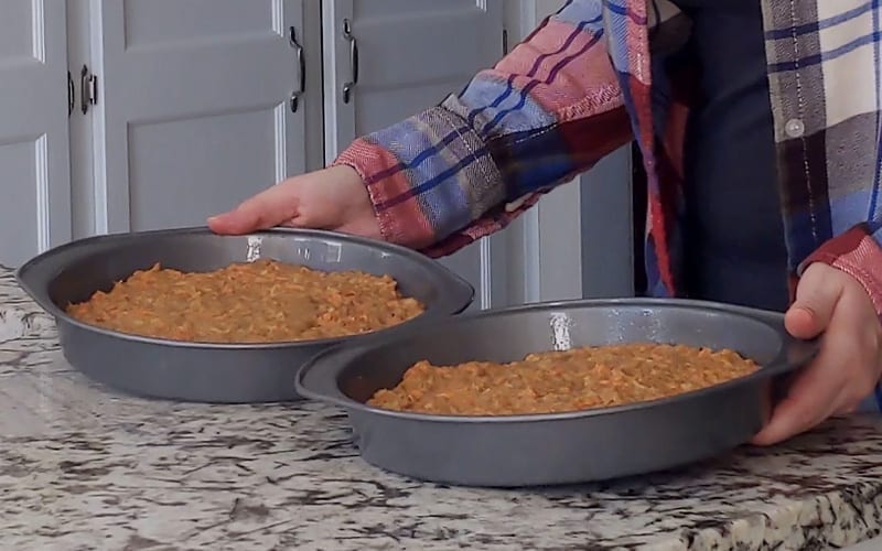 Two metal baking pans full of vegan carrot cake batter