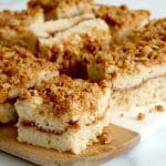 Close up of a board topped with square pieces of coffee cake topped with cinnamon streusel.