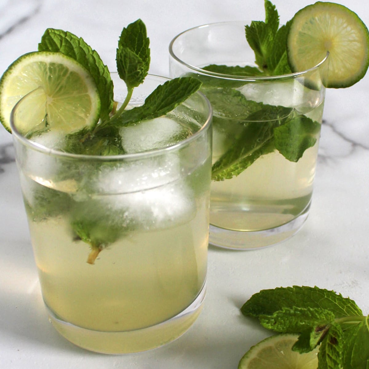 Two glasses of mint and lime mojito mocktails.