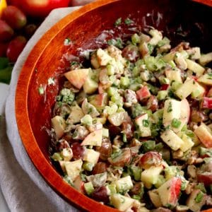 Close up of a large wood bowl filled with Waldorf salad.