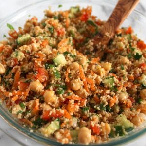 Close up of a large glass bowl filled with couscous salad.