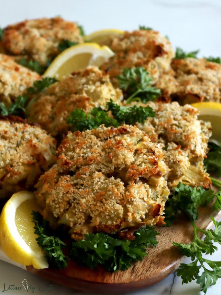 Platter of artichoke crabless cakes with parsley and lemon.