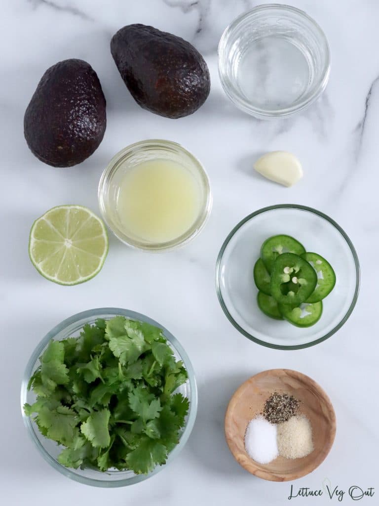 Ingredients for vegan avocado sauce (avocados, water, lime, garlic, cilantro, jalapeno pepper, spices).