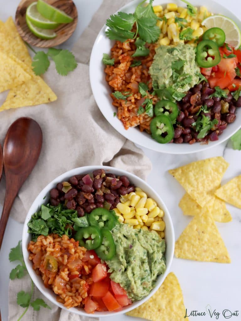 Two bean and rice burrito bowls with corn chips, cilantro and lime decorating image.
