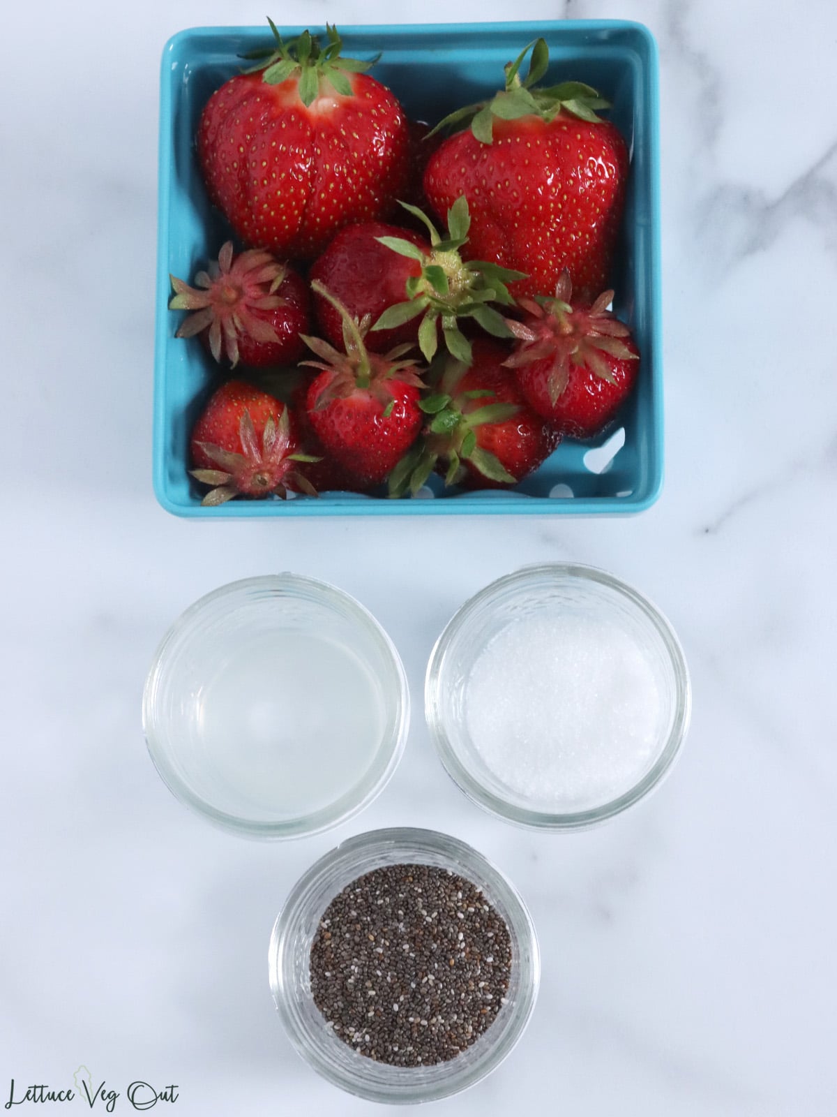 Ingredients for vegan strawberry jam (strawberries, sugar, lemon juice, chia seeds).