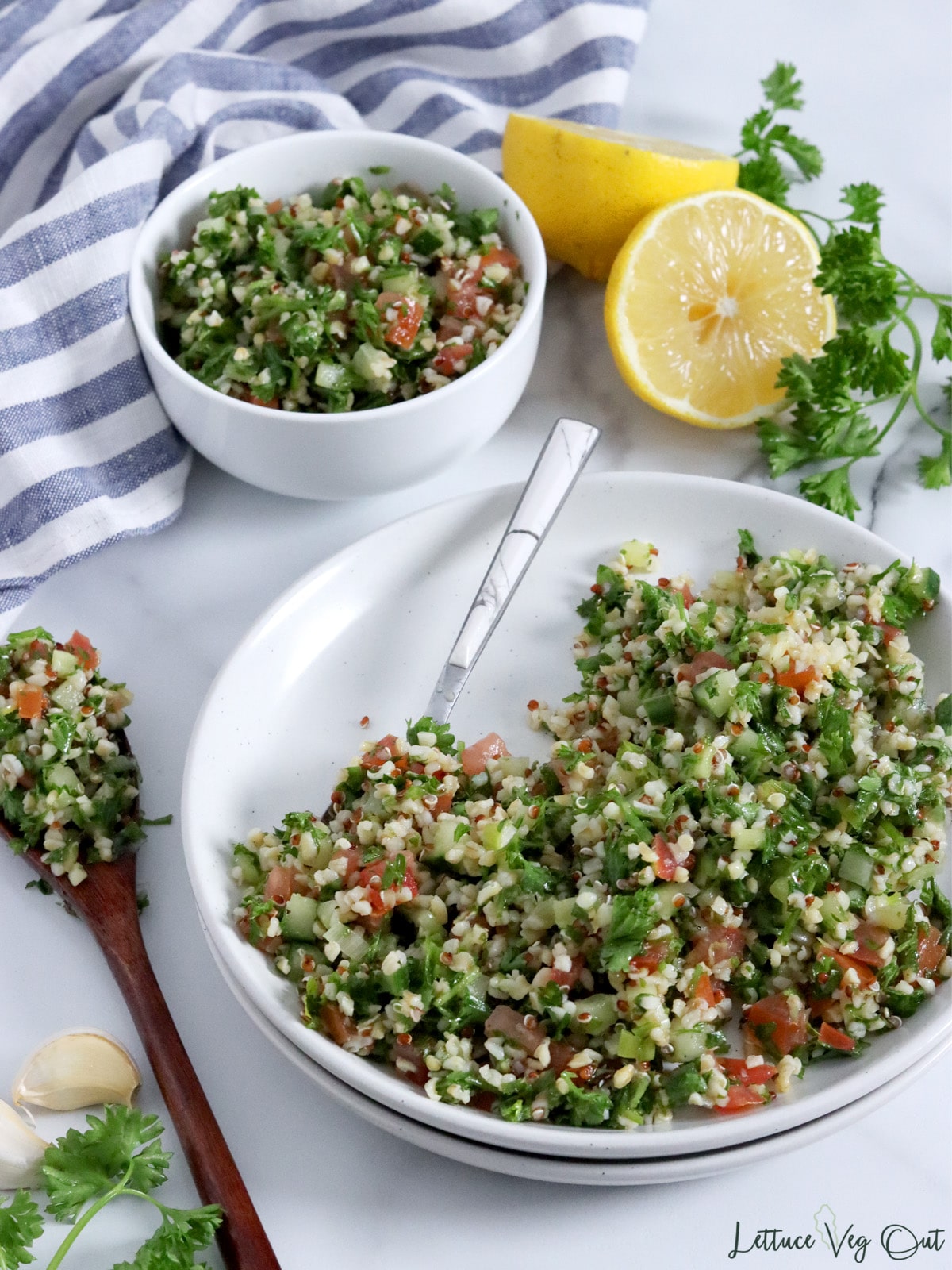 Plate of tabbouleh salad (parsley, bulgur, onion, tomato) with small bowl of salad in the back.
