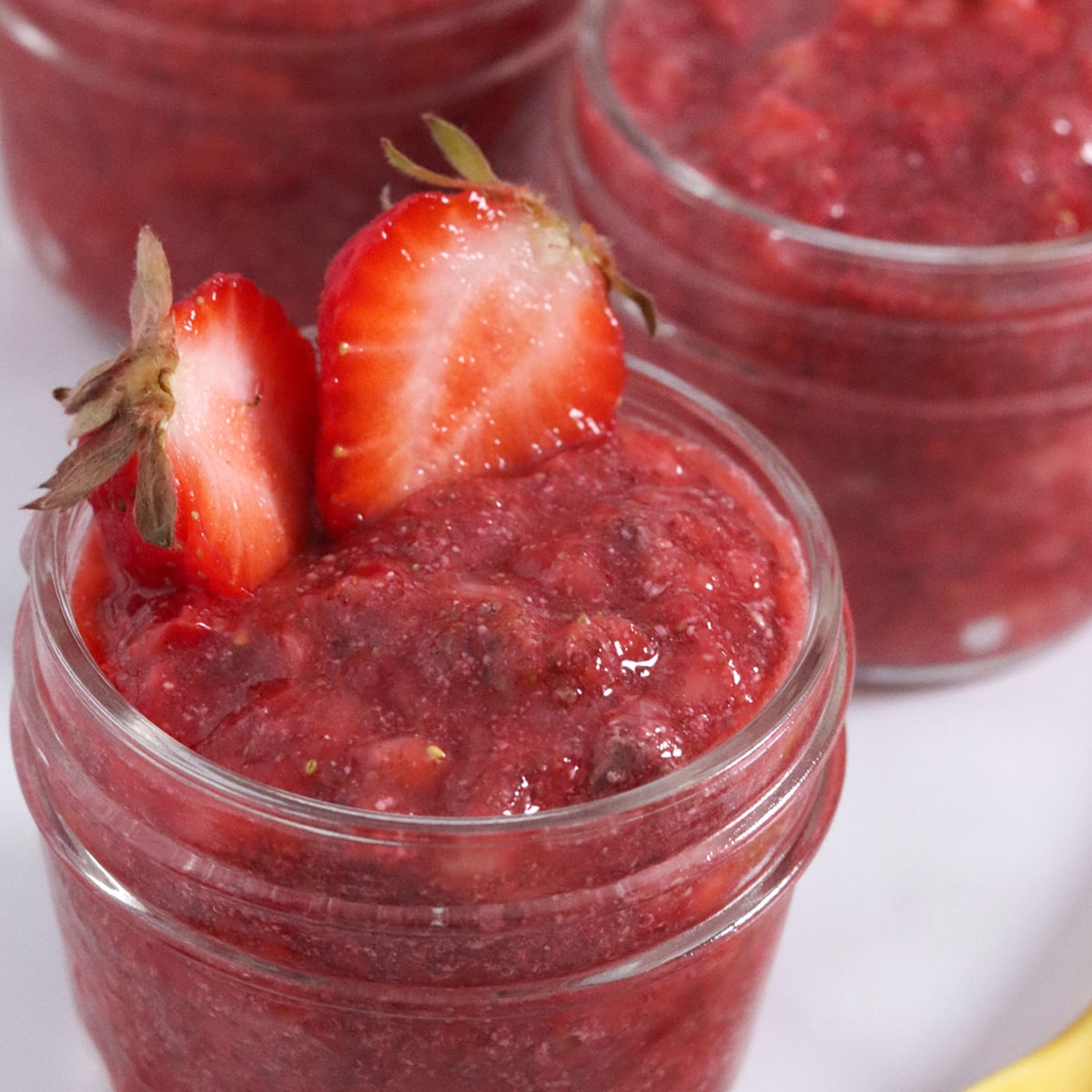 Close up of a small jar filled with strawberry chia seed jam.