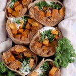Sweet potato burritos with refried beans and kale cut in half.
