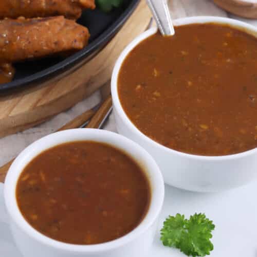 Close up of two small bowls of vegan brown gravy.