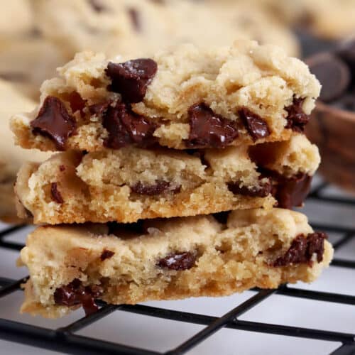 Close up of a stack of three chocolate chip cookies that are cut in half.